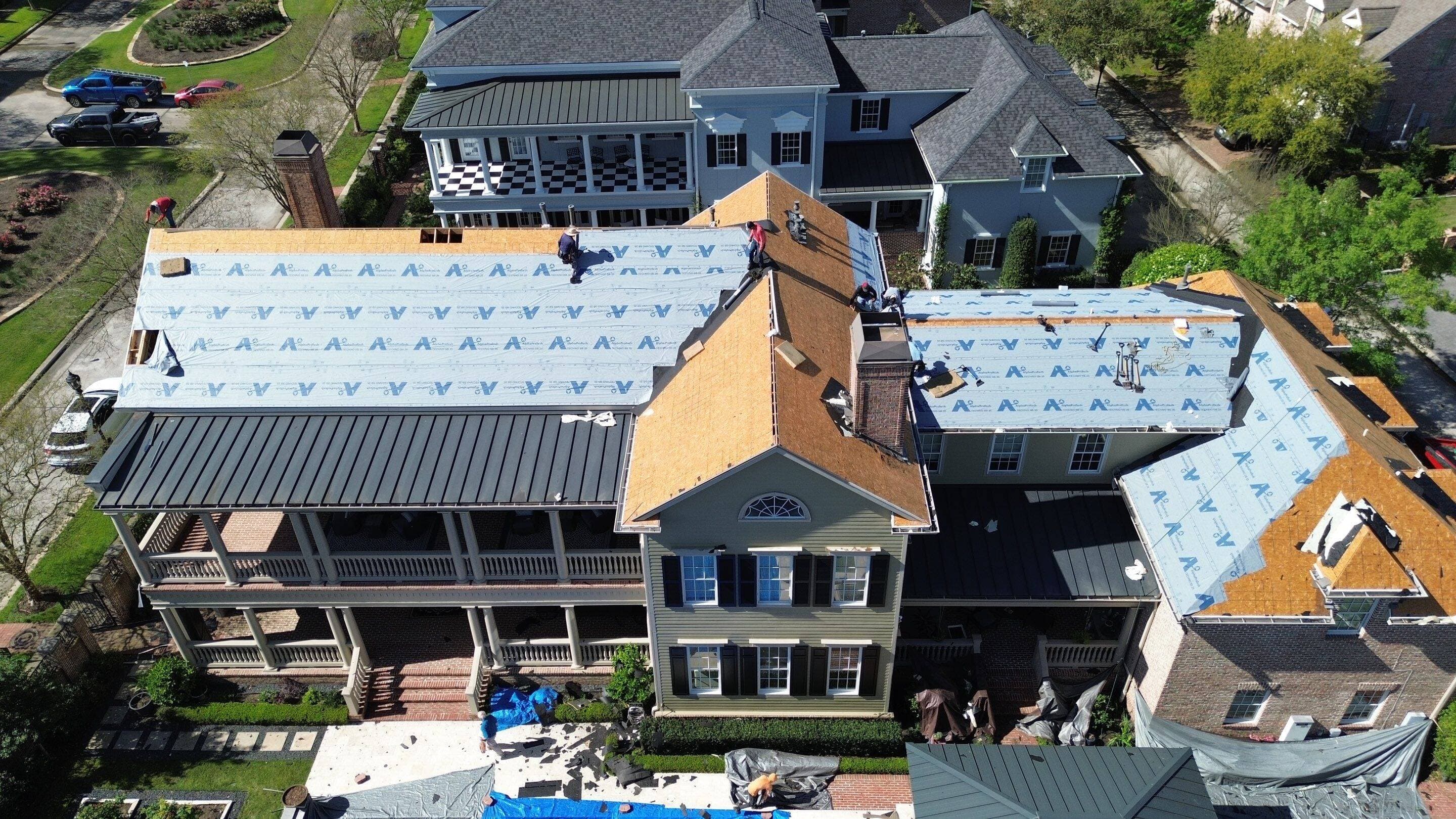 Drone view of a Roofing 365 crew mid-replacement on a large Montgomery County home